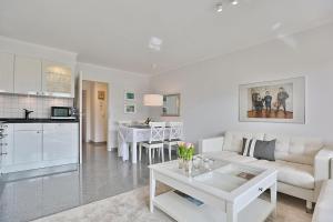 uma sala de estar com um sofá branco e uma mesa em Am Elchgrund, im Brook 9 Am Elchgrund Im Brook 9 Appartement 02 em Timmendorfer Strand