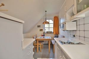 een keuken met een tafel en een eetkamer bij Am Rosenhain 23 Am Rosenhain 23 Appartement 05 in Timmendorfer Strand