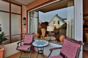 d'une terrasse avec 2 chaises et une table sur un balcon. dans l'établissement Wohnpark Niendorf Wohnpark Niendorf Appartement 05, à Niendorf