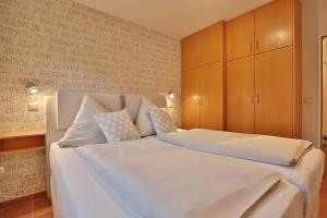 a bedroom with a large bed with white sheets at Am Rosenhain 23 Am Rosenhain 23 Appartement 01 in Timmendorfer Strand