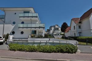 ein großes weißes Haus mit Balkon auf einer Straße in der Unterkunft Haus Wolburgstraße 1 Haus Wolburgstraße 1a Penthouse Haifisch Appartement 5 in Timmendorfer Strand