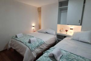 1 dormitorio con 2 camas y escritorio con espejo en Diego&Sergio3 Apartment Rivero Jacuzzi Piso3, en Huaraz