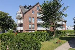 ein großes Backsteingebäude mit einem Baum davor in der Unterkunft Residenz Alte Bergstraße Residenz Alte Bergstrasse Appartement 5 in Scharbeutz