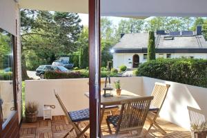 un patio con mesa, sillas y sombrilla en Gorch Fock Ring Strand und Meer Appartement 1, en Scharbeutz