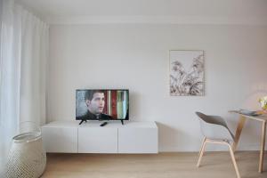 een woonkamer met een tv op een witte kast bij Residenz Alte Bergstraße Residenz Alte Bergstrasse Appartement 17 in Scharbeutz