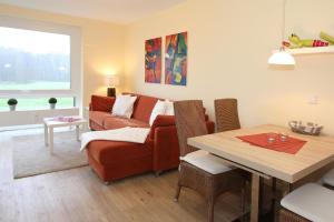 ein Wohnzimmer mit einem Sofa und einem Tisch in der Unterkunft Haus Nautica Nautica Appartement 9 in Haffkrug