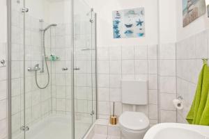 a white bathroom with a shower and a toilet at Feriendomizil Strandblick Feriendomizil Strandblick Appartement 2 MeerSonne in Haffkrug +29 photos