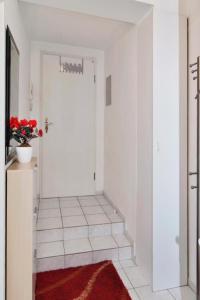 een hal met een witte deur en een rood tapijt bij Haus Parkblick Parkblick Appartement 1 in Scharbeutz