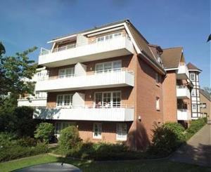 een groot bakstenen gebouw met een wit balkon bij Haus Parkblick Parkblick Appartement 1 in Scharbeutz