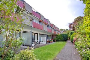 ein Gebäude mit einem grünen Hof neben einem Gebäude in der Unterkunft Haus Adria Haus Adria Appartement 29 in Scharbeutz