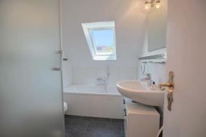 a white bathroom with a sink and a bath tub at Ferienhaus Seeweg 1 Ferienhaus Seeweg 1 in Klingberg +55 photos