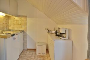 una pequeña cocina blanca con fregadero y encimera en Appartemenhaus Linda-Lu Appartementhaus Linda-Lu Appartement 7, en Scharbeutz