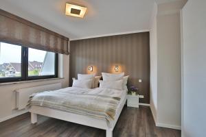a bedroom with a large bed and a window at Haus Stranddistel Stranddistel Appartement 2 in Scharbeutz