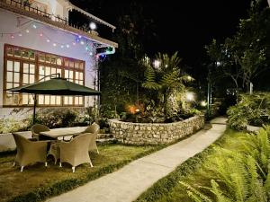 uma mesa e cadeiras num jardim à noite em Noblestride Resort em Gangtok