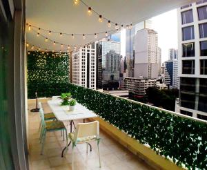 a balcony with a table and chairs and a view of a city at Habitaciones privadas en un departamento encantador in Panama City