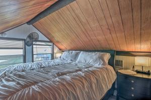 a bed in a room with a wooden ceiling at Walk to Shore: Cottage w/ Deck in Surfside Beach! in Freeport