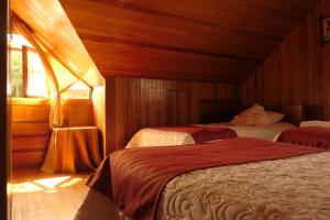 1 dormitorio con 2 camas y ventana en Albergue Turístico Böttger, en Oxapampa