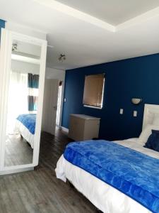 a blue bedroom with a bed and a mirror at Lior-Gil accommodation- in Kempton Park +123 photos