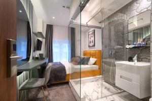 Schlafzimmer mit einem Bett, einer Dusche und einem Waschbecken in der Unterkunft NATALI Luxury suites in Belgrad