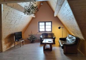 a living room with two leather chairs and a tv at Chochlik in Ustrzyki Dolne