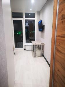 a room with a table and a television and a window at NEW STUDIO in ARCADIA in Odesa