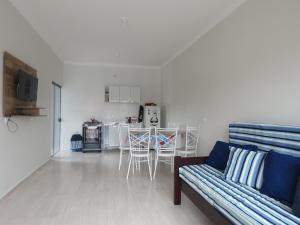 a living room with a couch and a kitchen at Casa do amor, vc pode ir andando até a praia in Itapoa