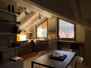 una cucina con tavolo e sedie e due finestre di Hérisson ad Aosta
