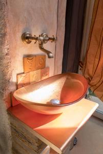 um lavatório de casa de banho com uma tigela de cobre numa mesa em CasaRosada WITH WELLNESS & SPA EXTRA em Vidracco