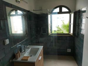 łazienka z umywalką i 2 oknami w obiekcie Casa Frajo w mieście Fuseta