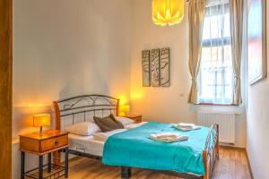 1 dormitorio con 1 cama con manta azul en Central Capital Apartments en Budapest