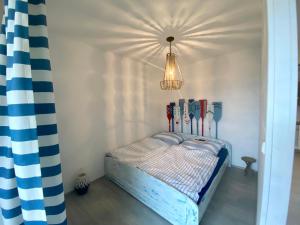 een kleine slaapkamer met een bed met een kroonluchter bij LIP no.15 in Lipno nad Vltavou
