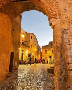 an alley in an old town with an archway at Residenza Matilde in Fiumefreddo Bruzio