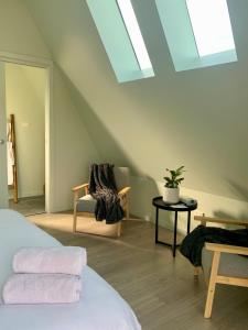 a attic room with a bed and a chair and a skylight at The Cove Tasmania in Devonport