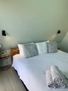 a white bed with two pillows on top of it at The Cove Tasmania in Devonport