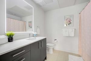 a white bathroom with a sink and a toilet at Downtown Denver Studio Less Than 1 Mi to Coors Field! in Denver +16 photos