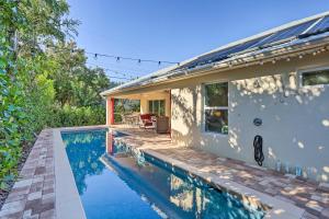 a swimming pool in front of a house at Chic Cocoa Beach Oasis with Pool - Steps to Shore! in Cocoa Beach