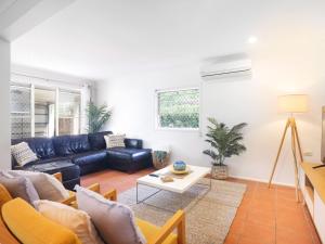 un salon avec un canapé et une table dans l'établissement Happy Dayz - Pet Friendly - Walk to Dog Beach, Restaurants & Playgrounds, à Gold Coast