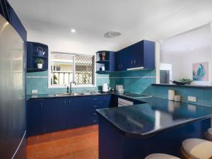 une cuisine bleue avec un évier et des armoires bleues dans l'établissement Happy Dayz - Pet Friendly - Walk to Dog Beach, Restaurants & Playgrounds, à Gold Coast 24 autres photos