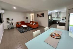 a kitchen and living room with a table and a couch at Lux in Bundy - Wifi, AC, Netflix and comfort in Bundaberg