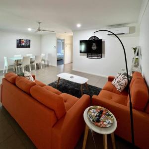 班达伯格Lux in Bundy - Wifi, AC, Netflix and comfort的客厅里有一张橙色的沙发和一张桌子