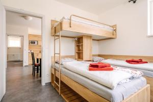 two bunk beds in a room with a table at Aura III in Boží Dar