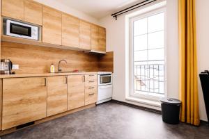 a kitchen with wooden cabinets and a large window at Aura III in Boží Dar