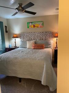 a bedroom with a large bed with a ceiling fan at Harvest House Bed and Breakfast in Springdale