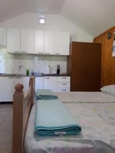 a kitchen with white cabinets and a table with towels at Holiday home Lidija - Robinson House in Postira
