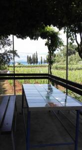 une table et un banc devant un champ dans l'établissement Holiday home Lidija - Robinson House, à Postira
