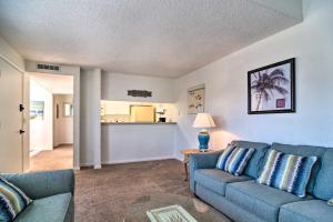 a living room with a blue couch and a table at Coastal Madeira Beach Condo - Walk to Gulf! in St Pete Beach