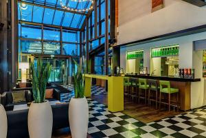 un restaurante con bar y algunas plantas en nestor Hotel Stuttgart-Ludwigsburg, en Ludwigsburg