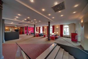 a large lobby with red furniture in a building at nestor Hotel Stuttgart-Ludwigsburg in Ludwigsburg +91 photos