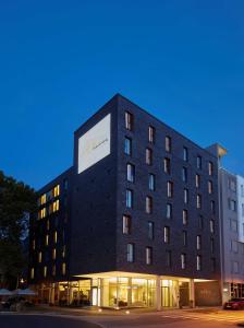 un bâtiment noir avec un panneau sur son côté dans l'établissement GHOTEL hotel & living Koblenz, à Coblence