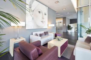 a living room with a large painting of a woman at GHOTEL hotel & living Koblenz in Koblenz